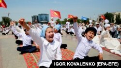Mектеп окуучулары Бишкектин Жеңиш аянтында "Манас" эпосун айтууда. 15-май, 2023-жыл.