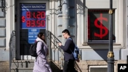 Egy pénzváltó iroda kijelzőjén az amerikai dollár és az orosz rubel árfolyama az oroszországi Szentpéterváron 2023 áprilisában