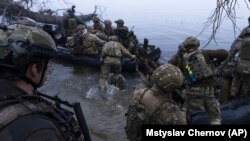 військовослужбовці сідають на катери біля берега Дніпра на Херсонщині, 15 жовтня 2023 року