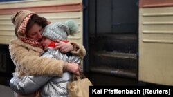 Майка прегръща дъщеря си, след като пристигат с влак от Харков в Лвов. 4 март 2022.