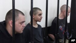 Британиялык Эйден Аслин, Шон Пиннер жана марокколук Саадун Брагим сот залында. Донецк шаары.