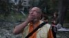 Утро 17 июня. Киевлянин смотрит на один из домов, разрушенных в результате российского удара