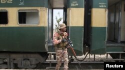 په بلوچستان کې یو پوځي سرتېری پر جعفر اېکسپرېس تر وسلوال برید وروسته پر پټلۍ پهره کوي - د مارچ ۱۲مې انځور.