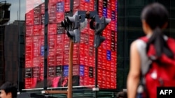 Panouri cu prețurile Nikkei 225 la Tokyo, pe 12 august 2025.