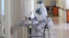 A medical worker takes notes at the Surb Grigor Lusarovich Medical Center in Yerevan, Armenia's largest hospital treating coronavirus patients, June 5, 2020.