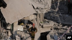 Izraelske sigurnosne snage pregledavaju uništene kuće koje je pogodila raketa ispaljena iz Irana u Rishon Lezionu u Izraelu u subotu, 14. juna 2025.