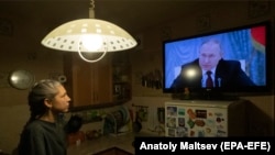 Žena u Sankt Peterburgu gleda televizijsko obraćanje predsjednika države Vladimira Putina, 21. februar 2022.