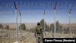 A soldier stands guard along the border fence at the Angoor Adda outpost on the border with Afghanistan in South Waziristan tribal district in western Pakistan.